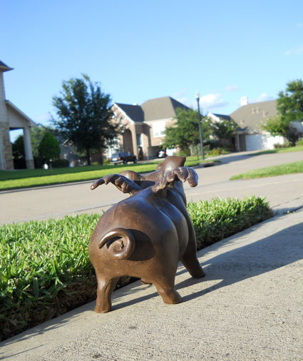 Statue of pig with wings, as if preparing to fly